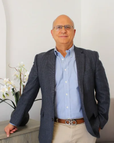 El rector José Antonio González Muñoz, de pie junto a un mueble con orquídeas